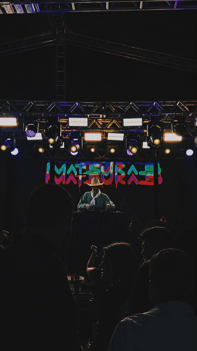 DJ Matsukas na cabine com letreiro do nome